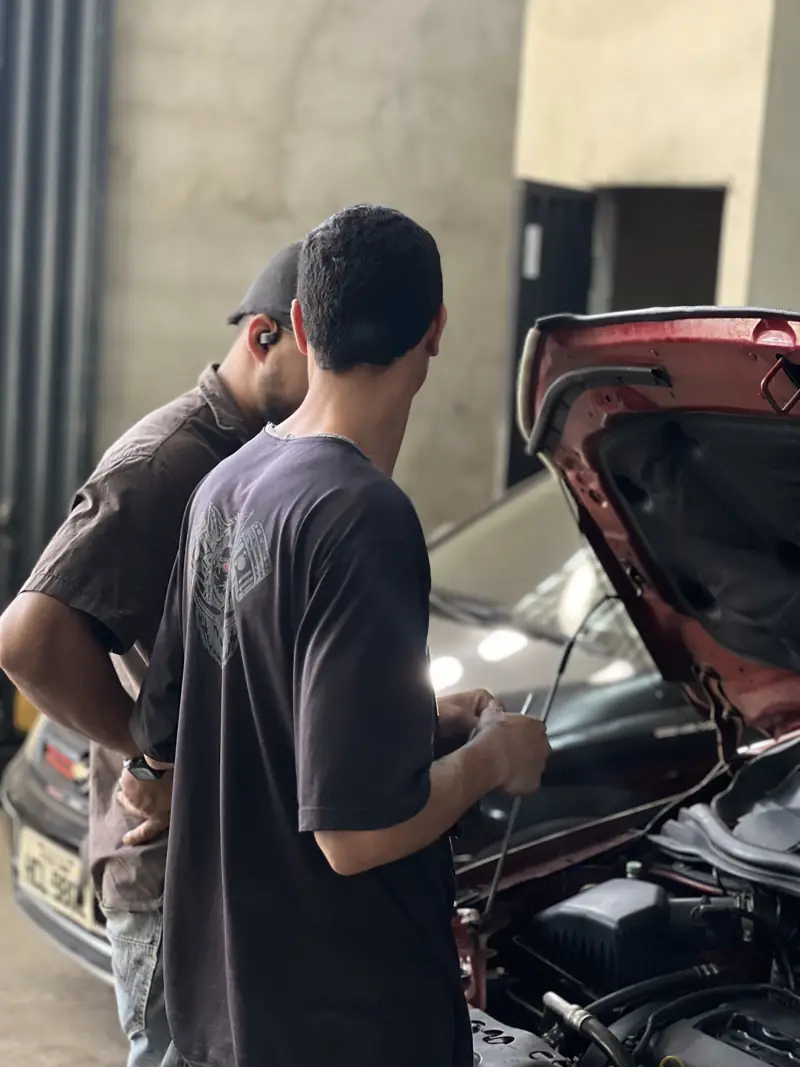 Mecânico explicando o diagnóstico ao lado do carro
